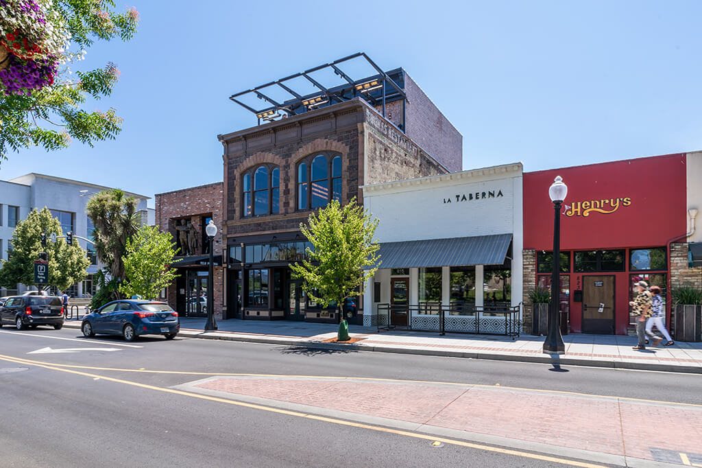 A street view with a car driving and a pedestrian walking
